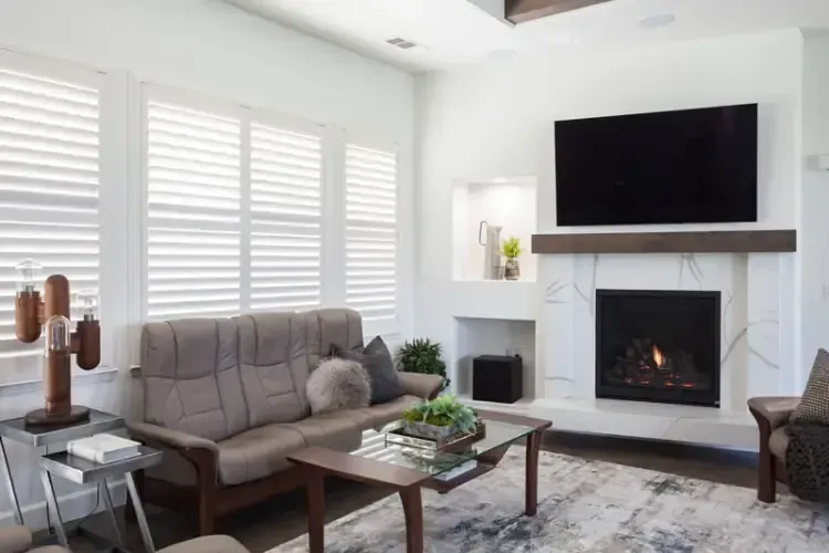 A living room with a fireplace , couch , coffee table and television.