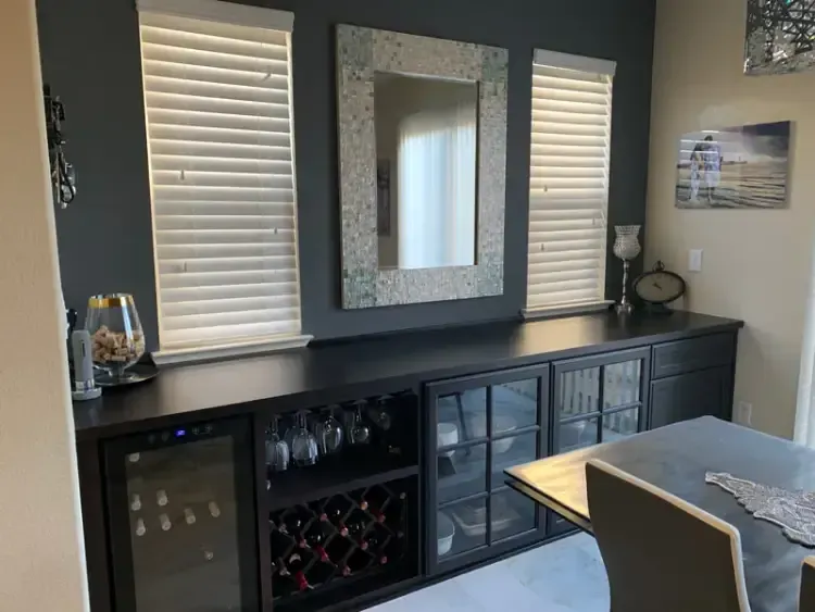 A dining room with a table , chairs , and a wine cooler.