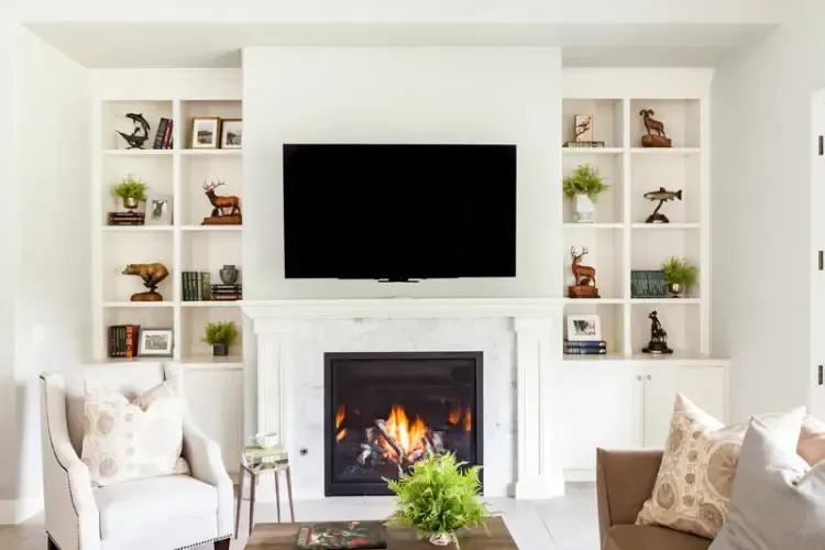 A living room with a fireplace and a flat screen tv on the wall.