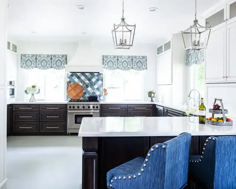 A kitchen with a large island and blue chairs.