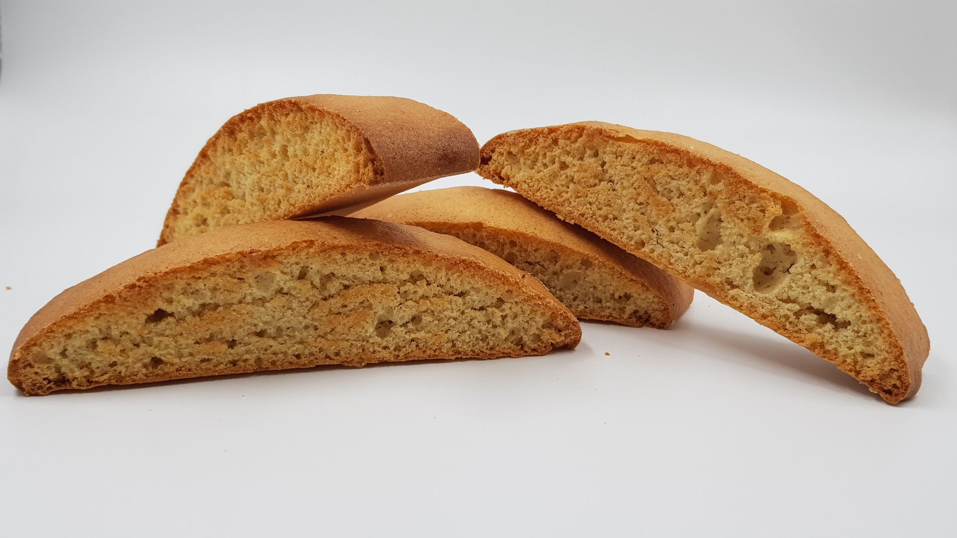 Quattro fette di pane sono disposte una sopra l'altra su una superficie bianca.