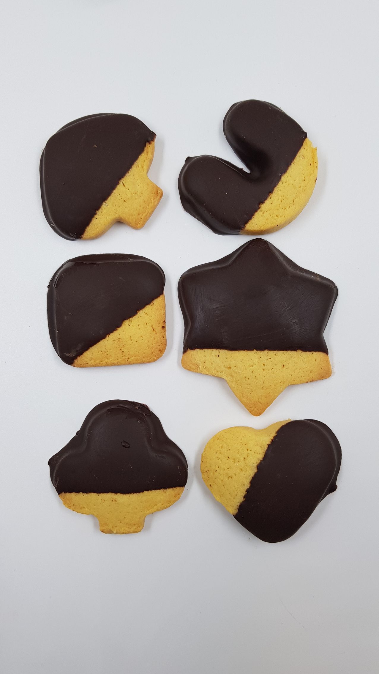 Un mucchio di biscotti di forme diverse sono ricoperti di cioccolato