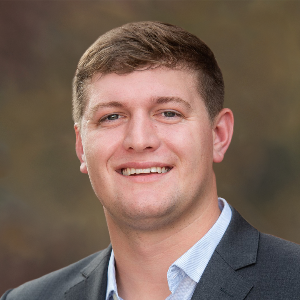 A man in a suit and white shirt is smiling for the camera.