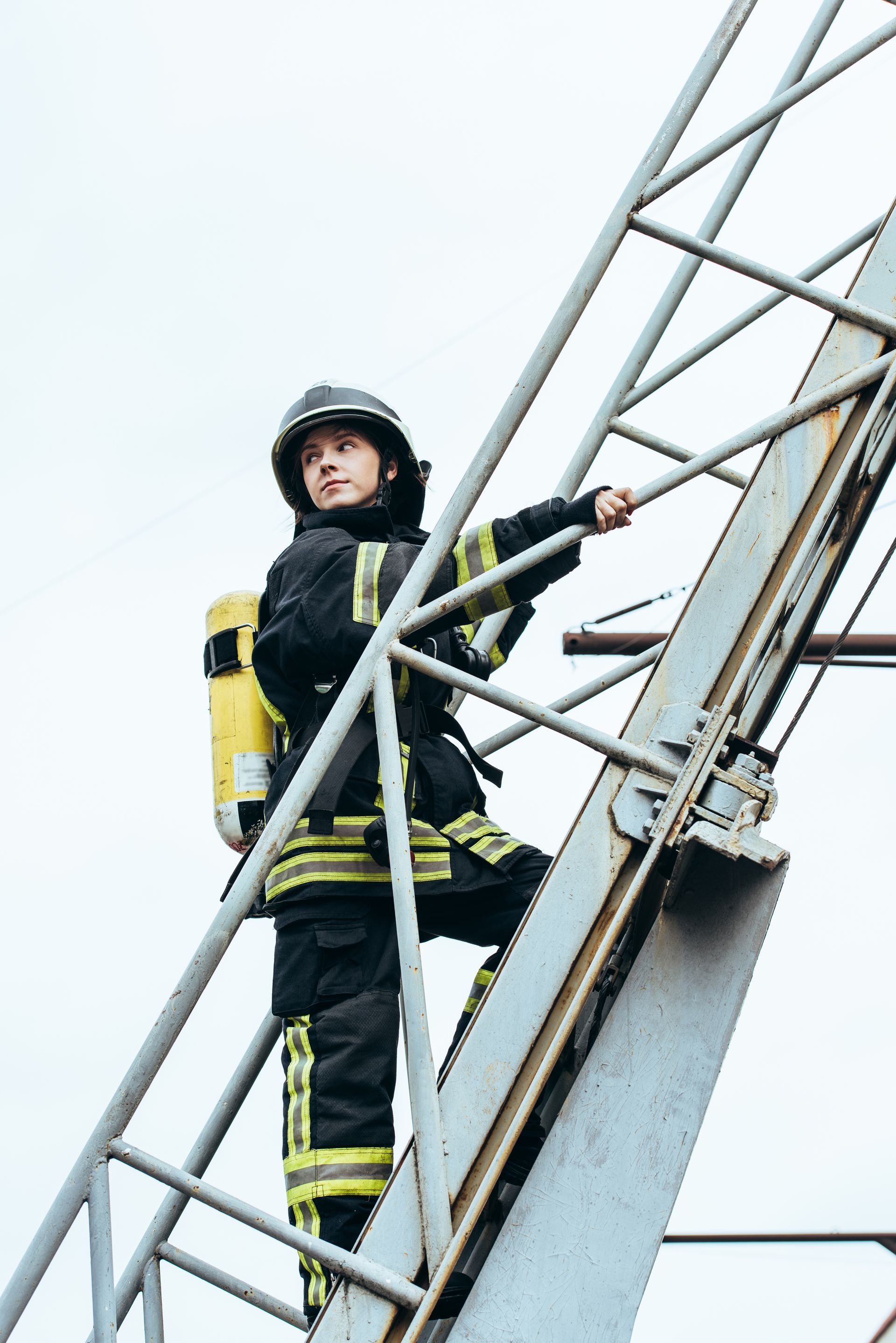 a fireman is standing on top of a ladder - public entity insurance