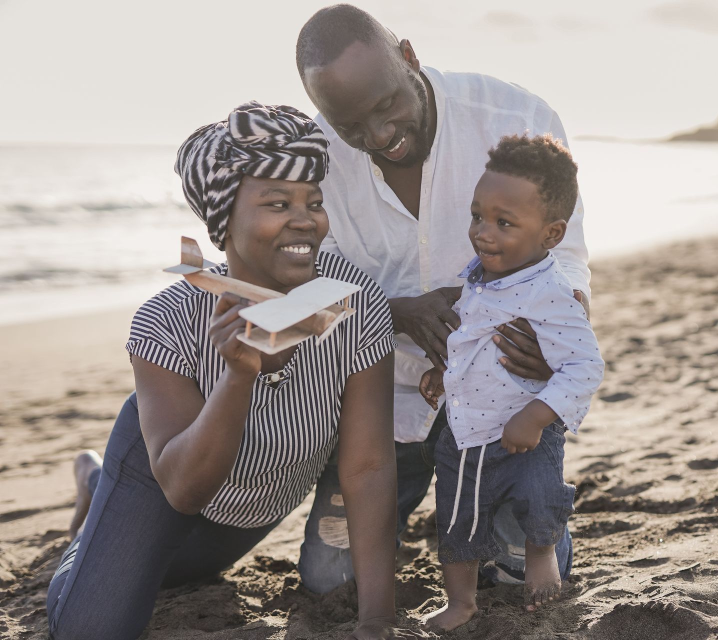 a family is playing on the beach while considering life insurance