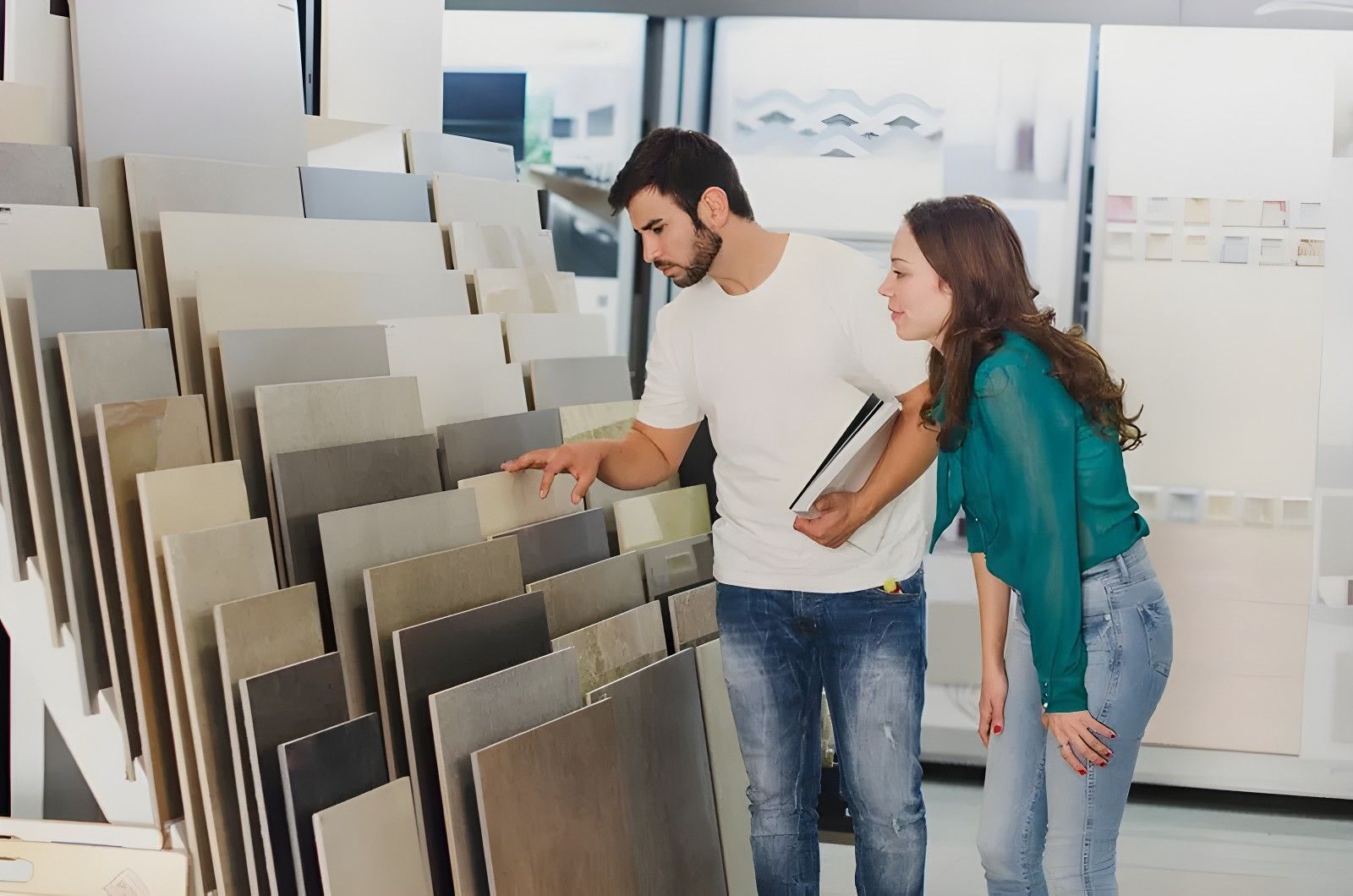 A Man and Woman Browse Tile Samples in a Showroom, Examining a Selection of Neutral-coloured Tiles — North Coast Tiles in Grafton, NSW