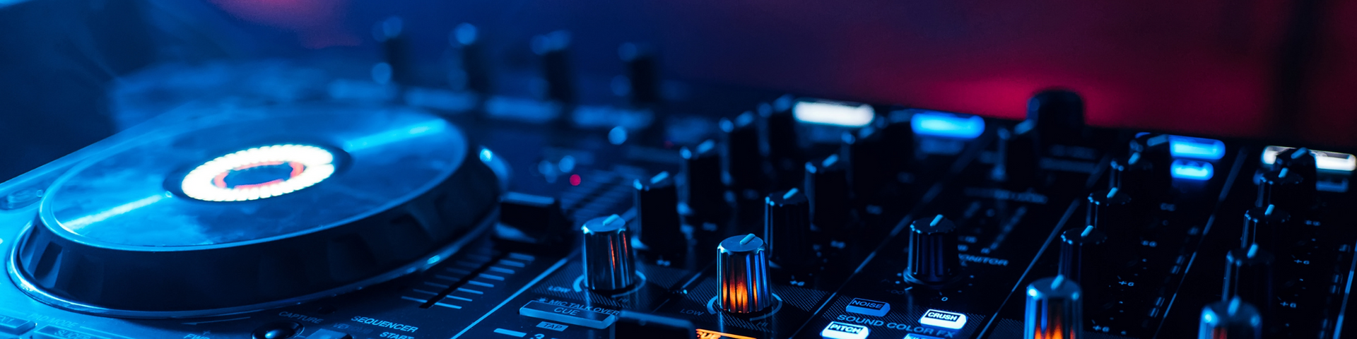 Blue-lit DJ turntable and mixer controls in a dark studio setup