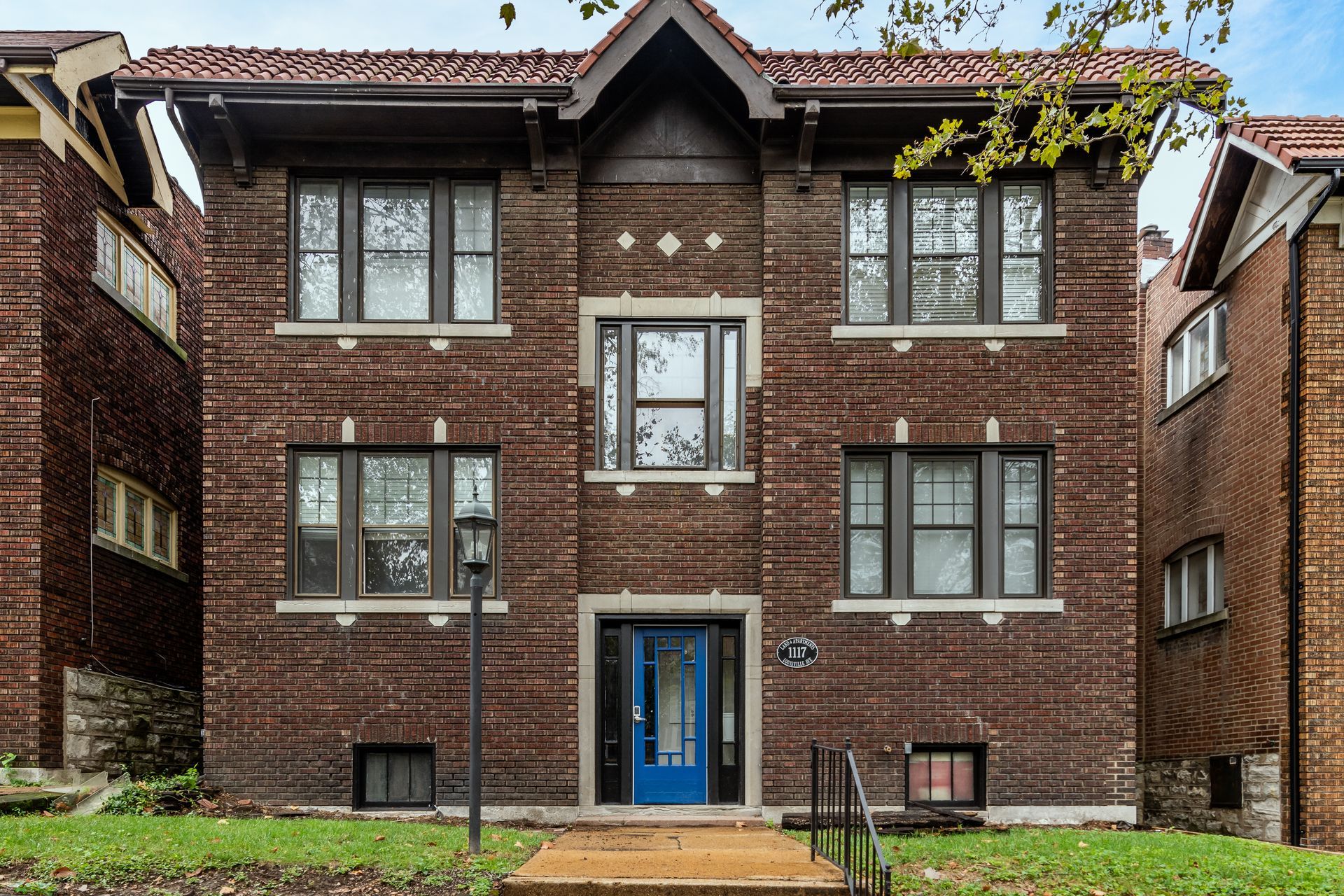 A large brick apartment building with a blue door