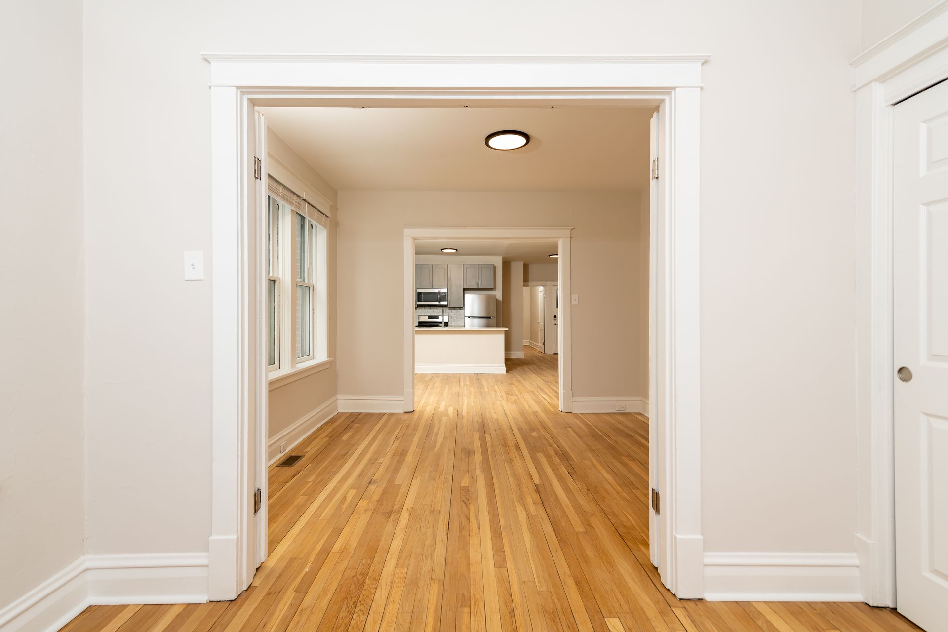 An empty room with hardwood floors and white walls.