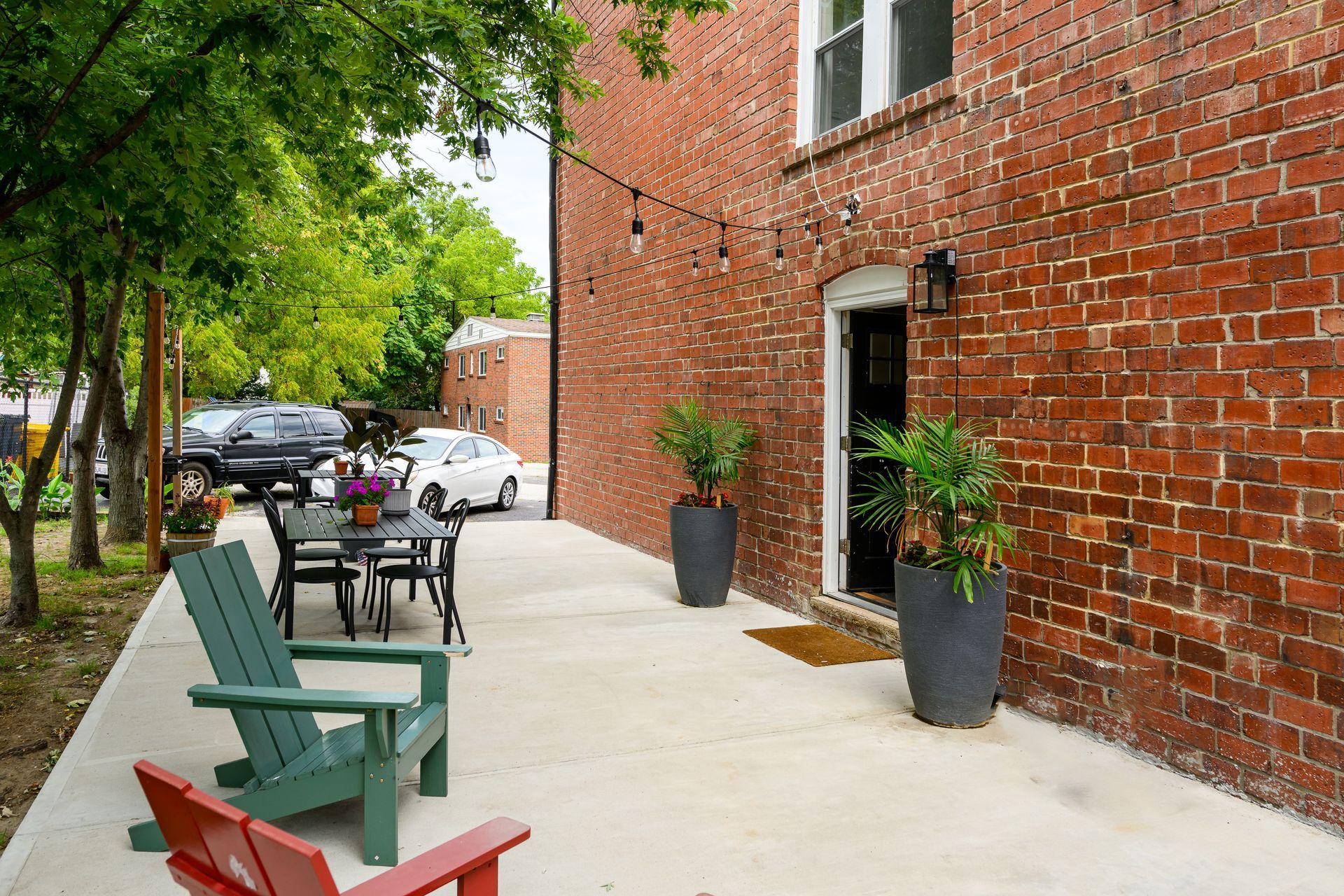 A patio with chairs and a table in front of a brick building.