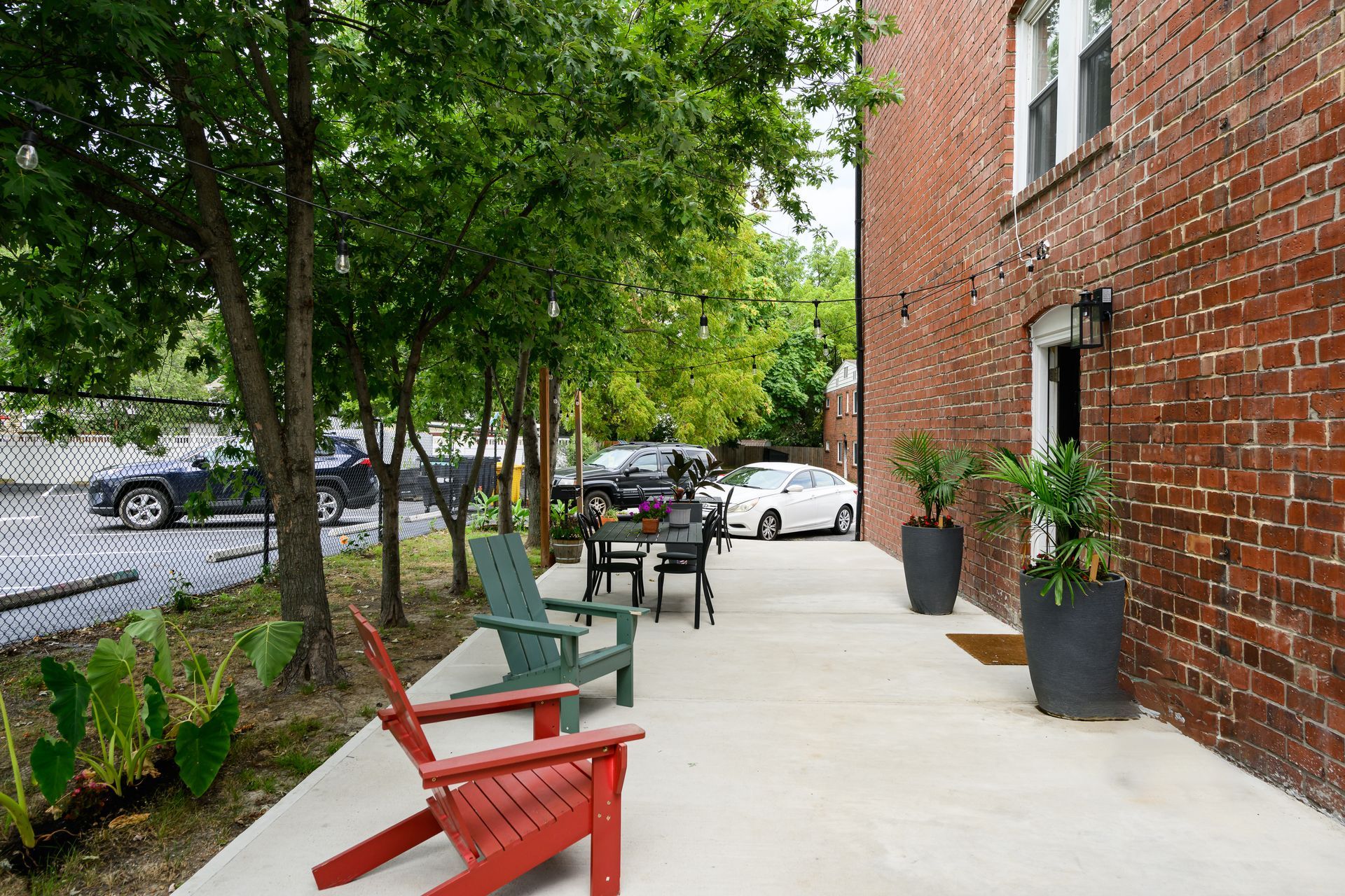 A brick building with a patio area with chairs and a table.