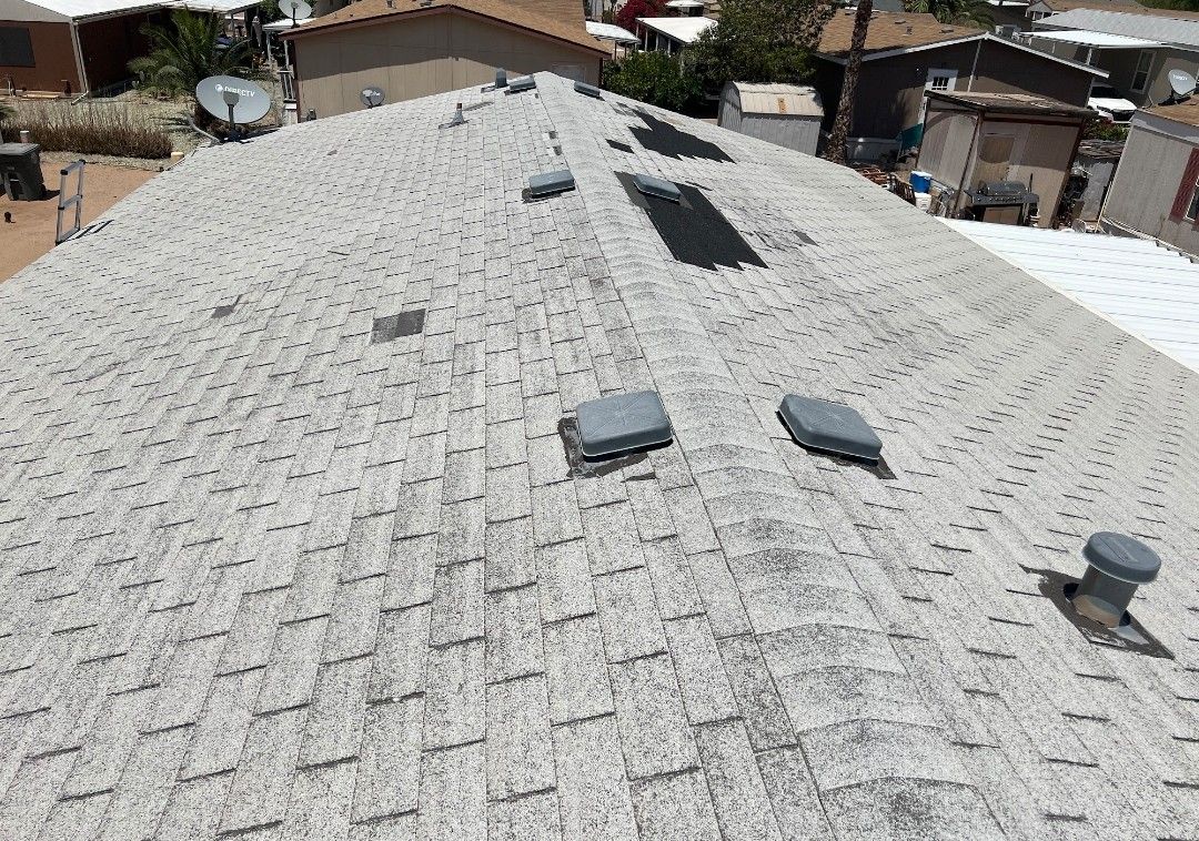 Gray, weathered asphalt shingle roof with several vents.