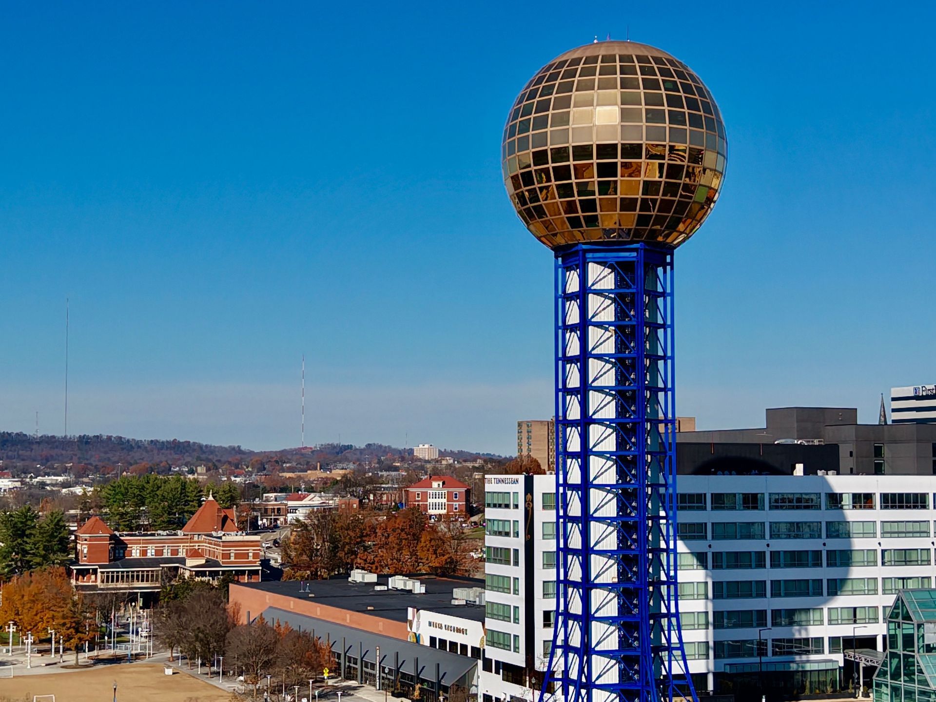 Golden Sphere tower above city buildings under a clear blue sky