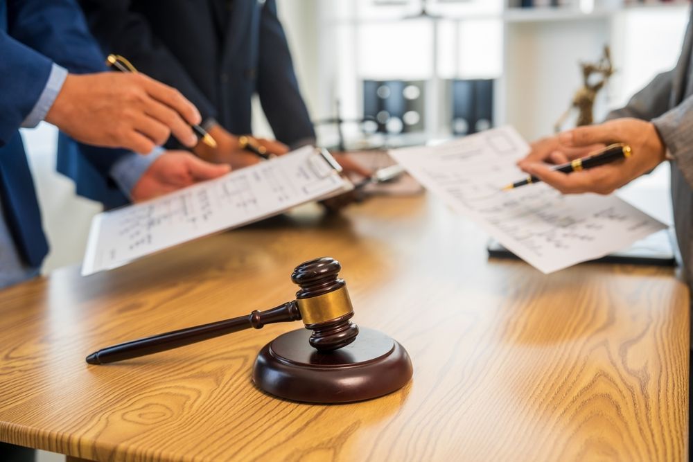 Lawyers reviewing documents around a gavel in a conference room
