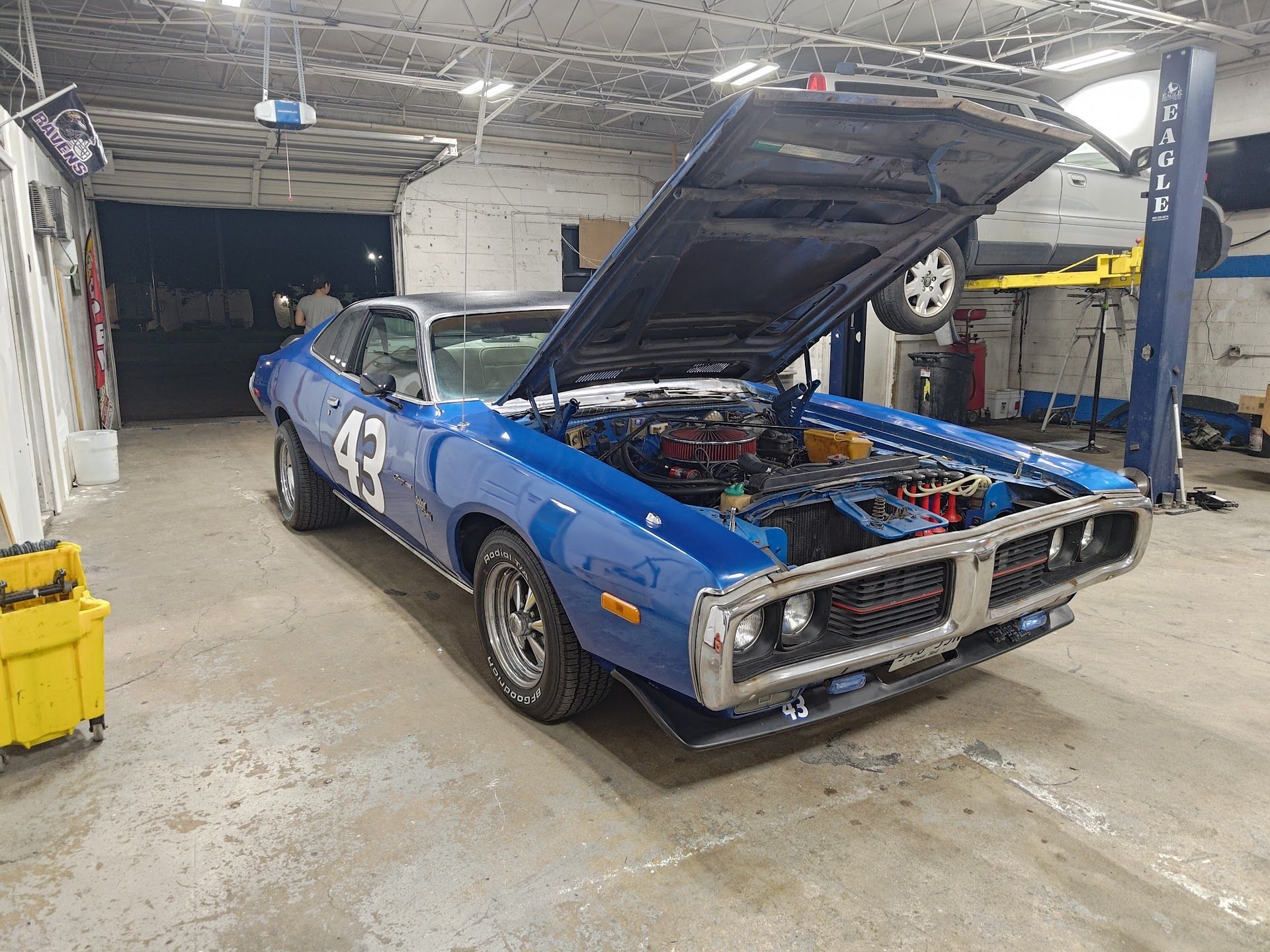 Blue race car with hood open in a garage | La Saga Auto