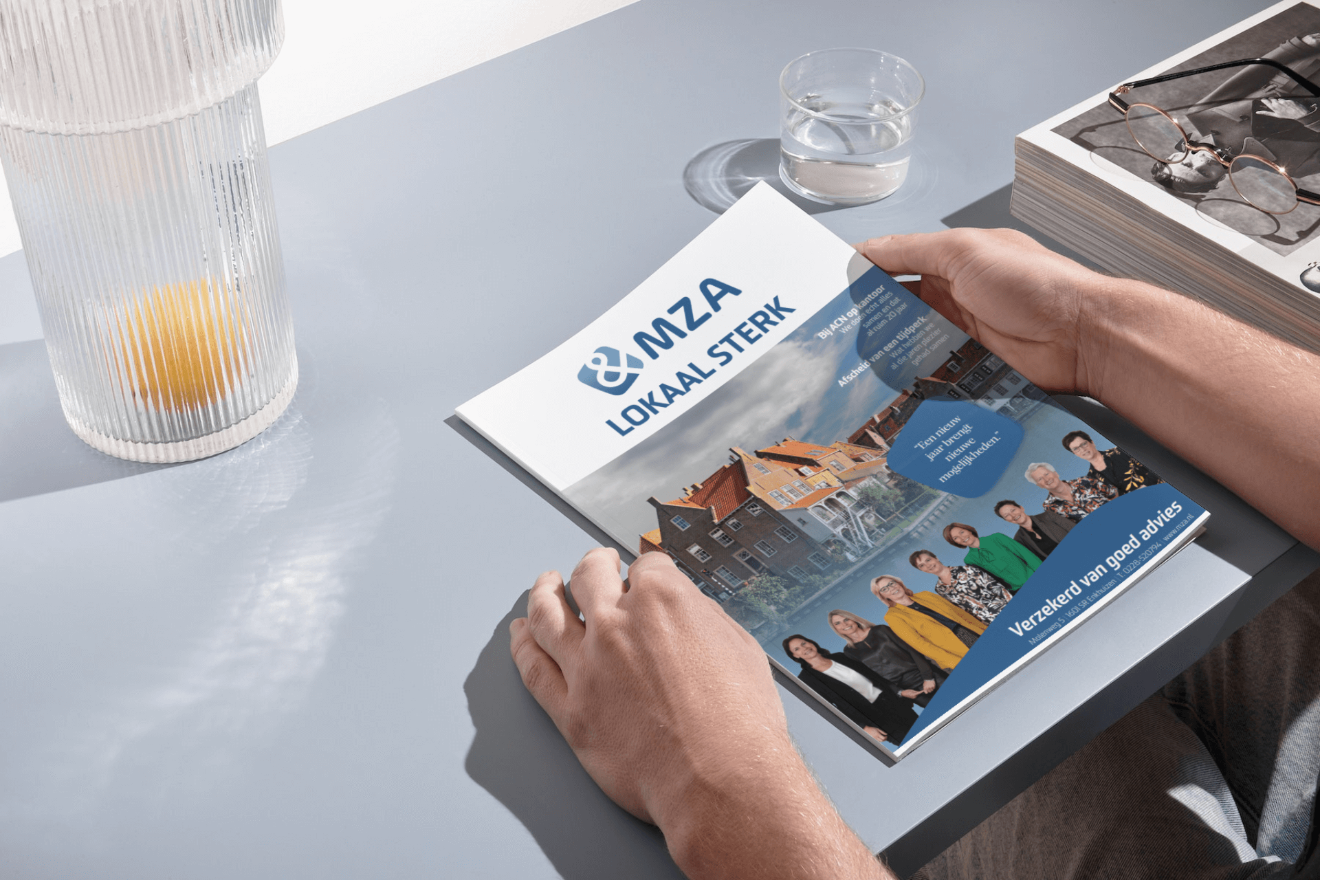 Een persoon houdt een tijdschrift van MZA vast.
