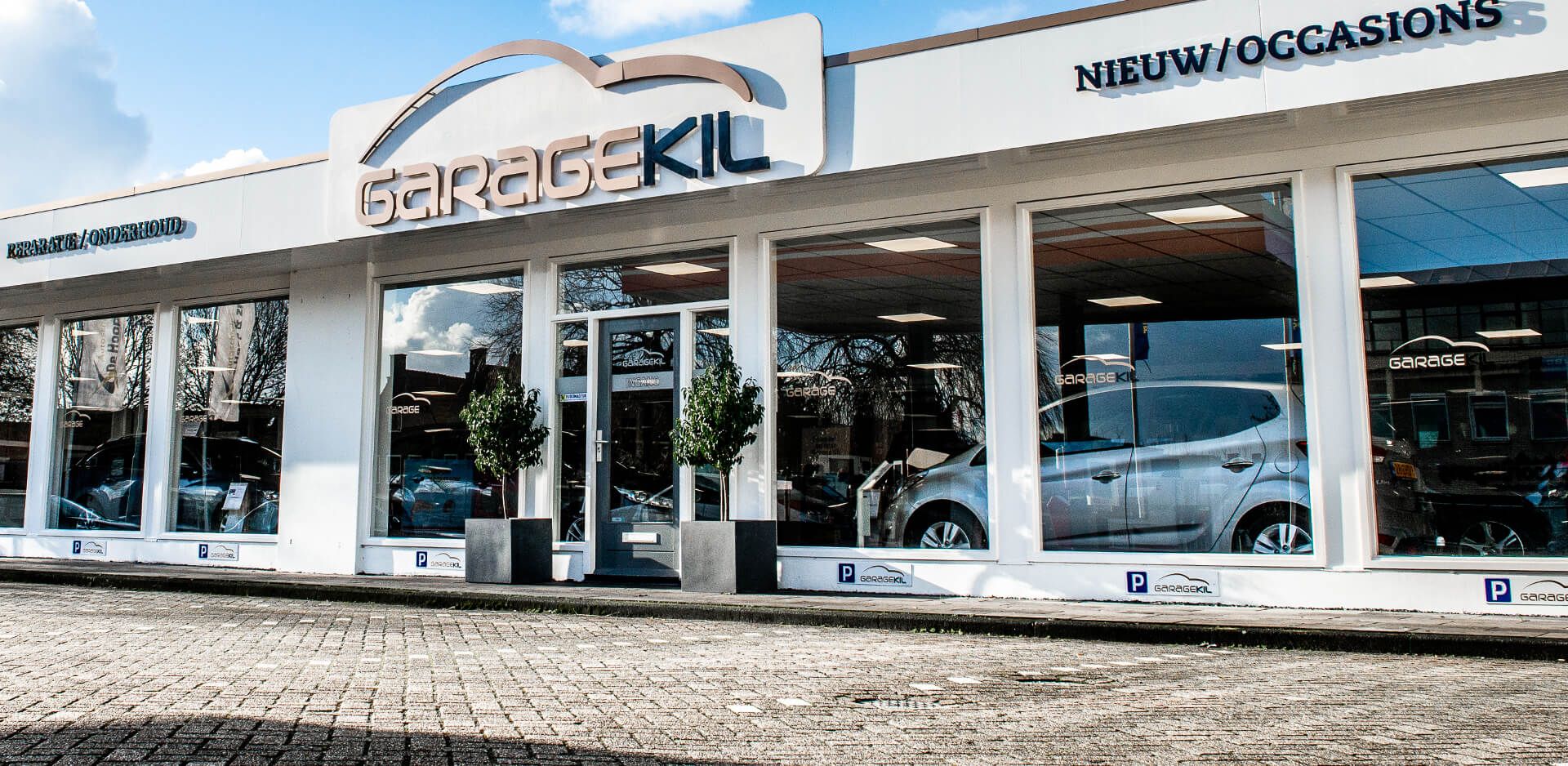 Een autodealer met Garage Kil erop met auto's ervoor geparkeerd.