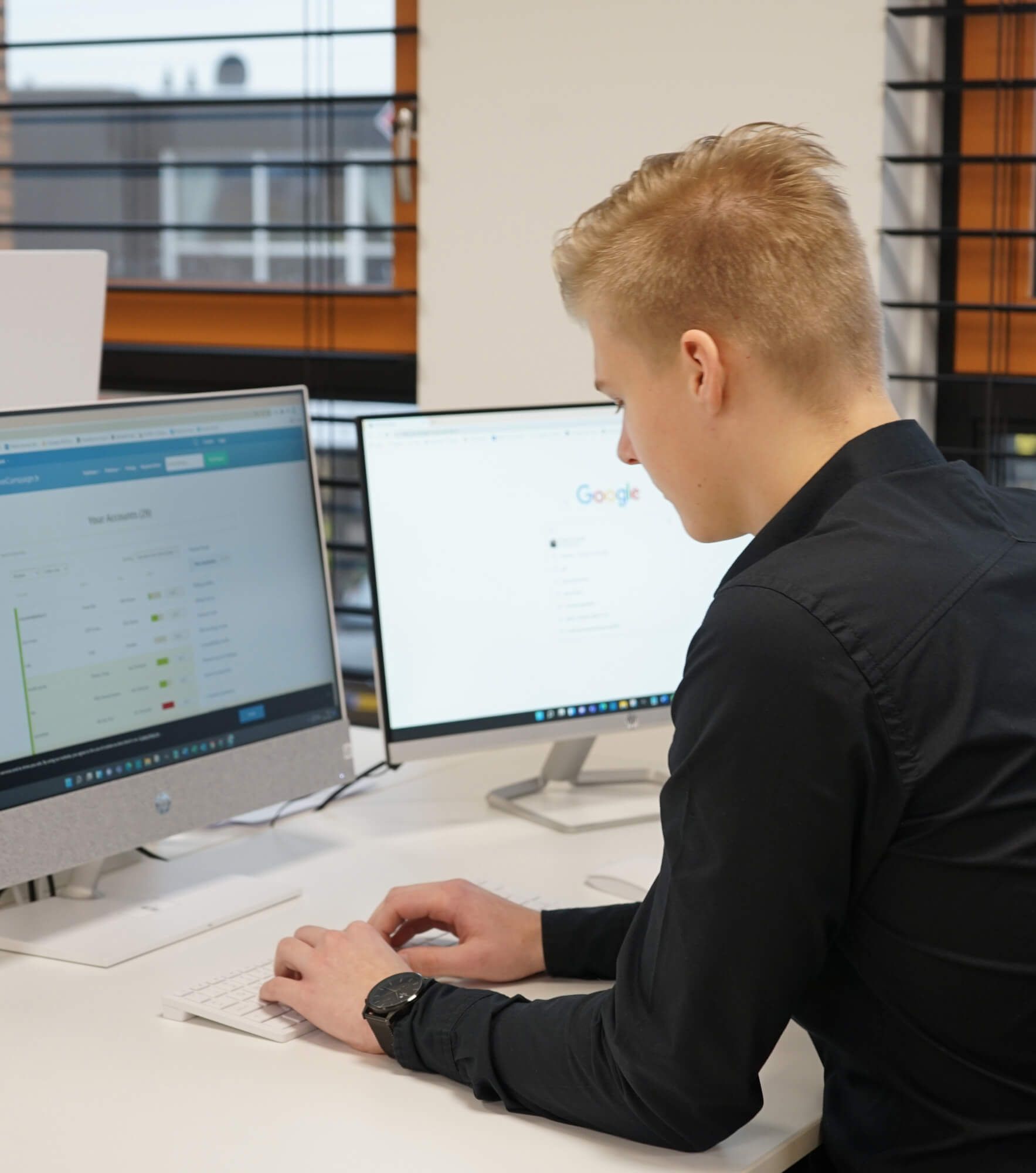 Kevin in een zwart shirt werkt op een computer