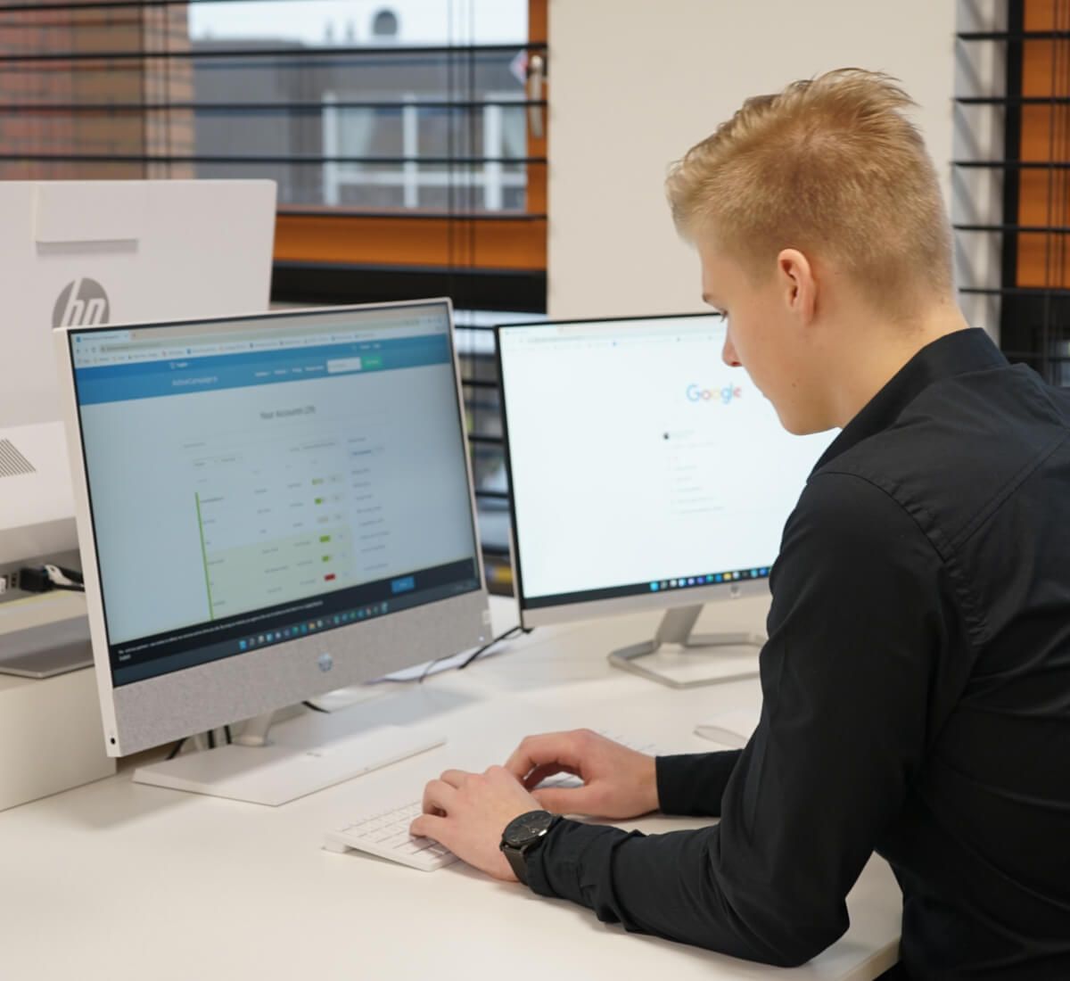 Kevin zit aan een bureau voor een HP-computer