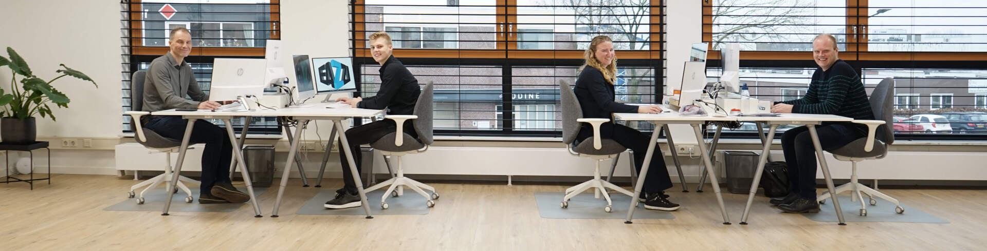 De medewerkers van EAZZI zitten aan hun bureau.