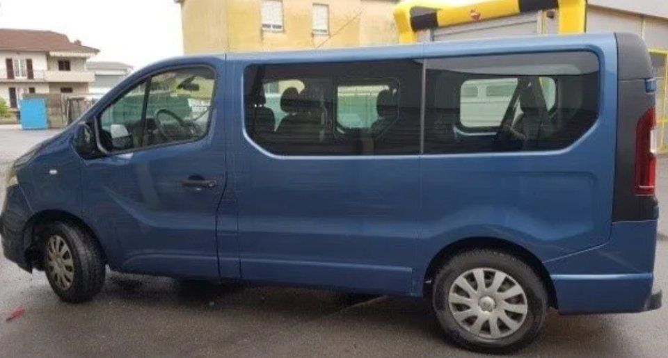 Furgone passeggeri blu parcheggiato in strada, vista laterale