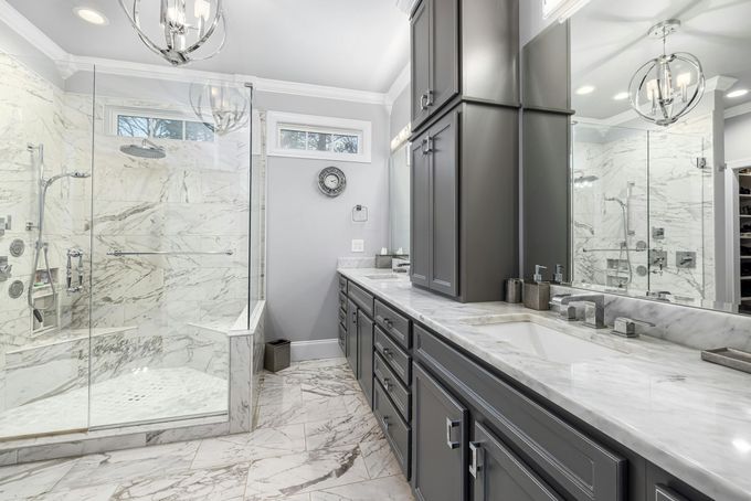 Bathroom remodeling with gray cabinets and marble tile and countertops