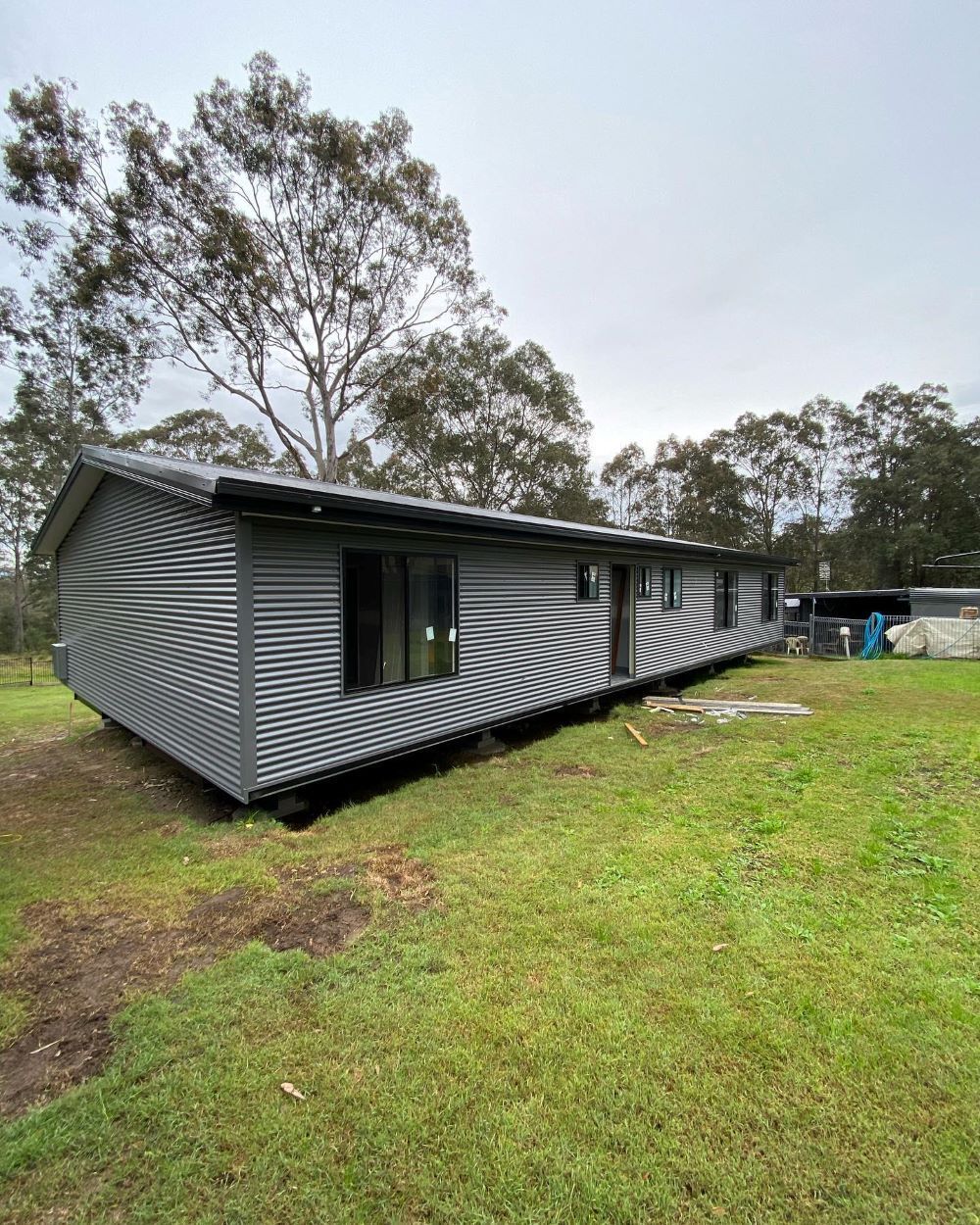 A Mobile Home is Sitting in the Middle of a Grassy Field — Lake Valley Roofing in Maitland, NSW