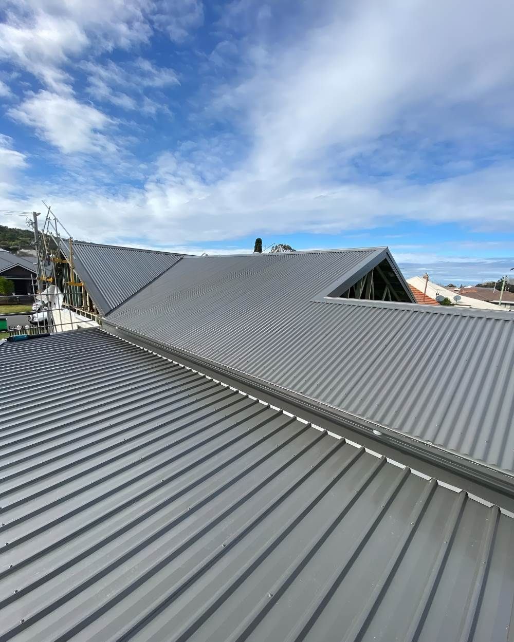 An Aerial View of a Metal Roof With a Blue Sky in the Background — Lake Valley Roofing in Mayfield, NSW
