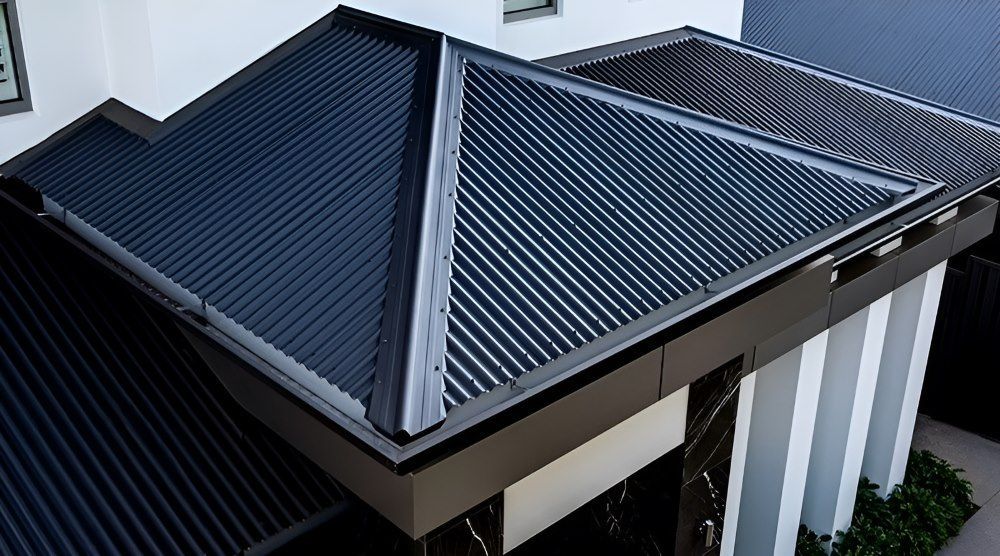 An Aerial View of a House With a Black Roof — Lake Valley Roofing in Redhead, NSW