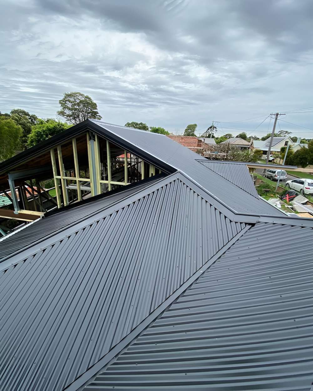 An Aerial View of a House Under Construction With a Corrugated Metal Roof — Lake Valley Roofing in Redhead, NSW