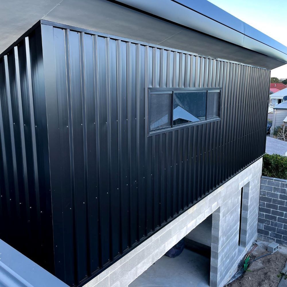 A Black Building With a Window on the Side of It — Lake Valley Roofing in Weston, NSW