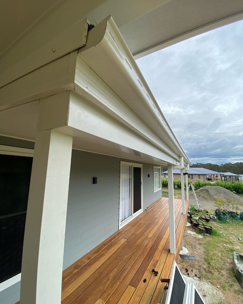 A House With a Wooden Deck and a White Gutter — Lake Valley Roofing in Cardiff, NSW