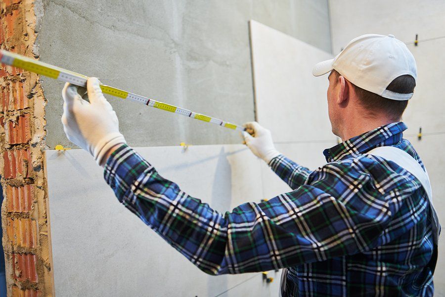 worker measuring the wall