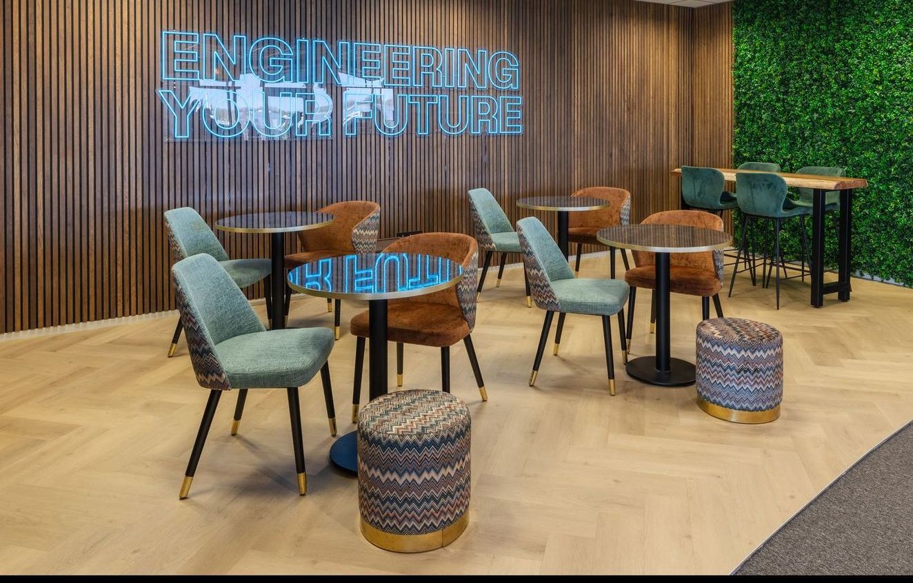 Cafe with tables, chairs, and neon sign that reads 