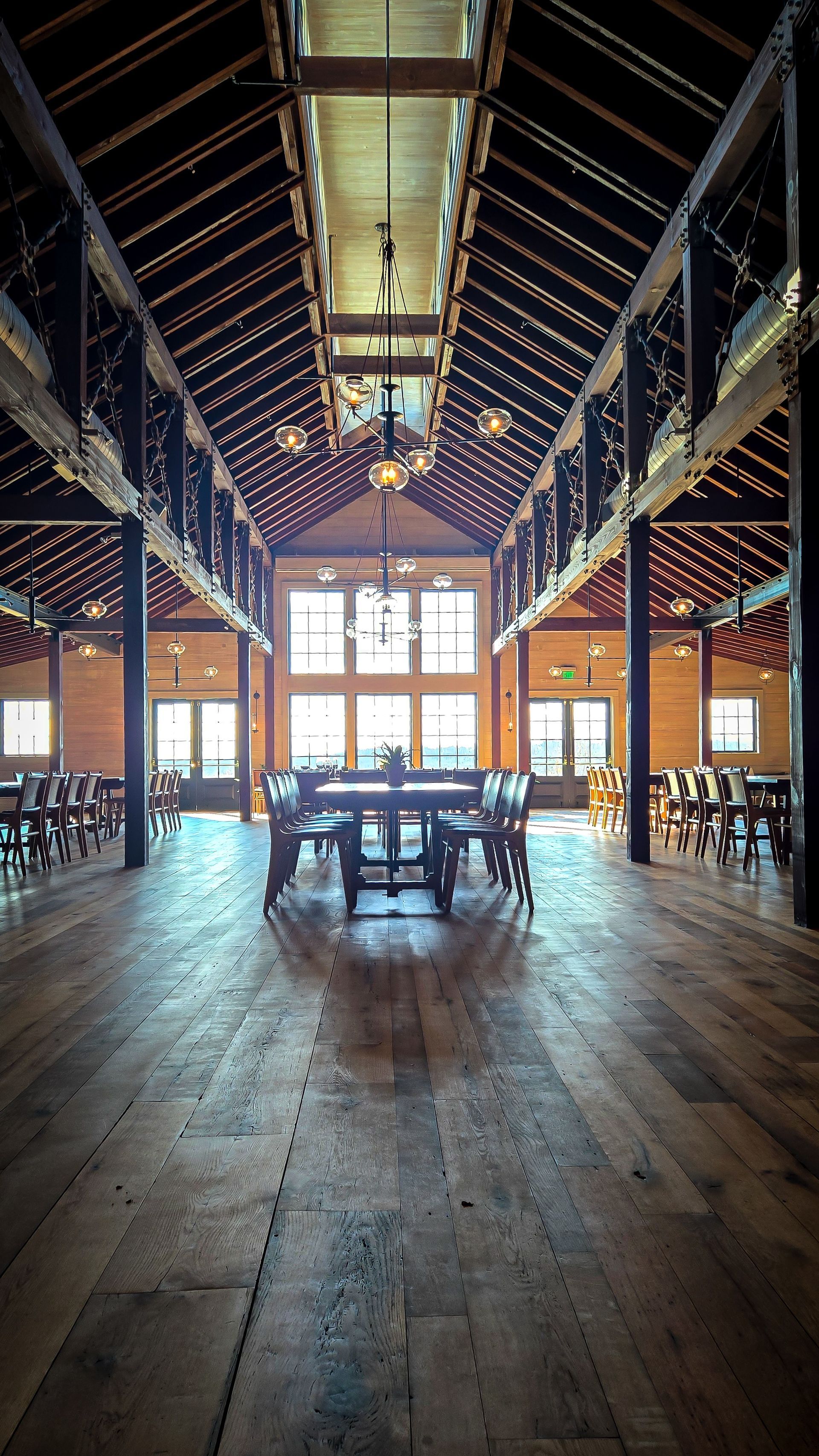 Timber-trussed barn interior set with long banquet tables at a Louisville-area wedding and corporate