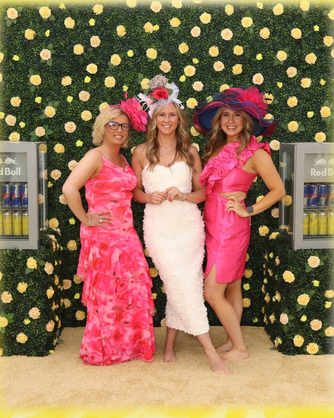 Kentucky Derby guests in hats at the Red Bull flower wall, photographed by the Pose 502 Portrait Booth