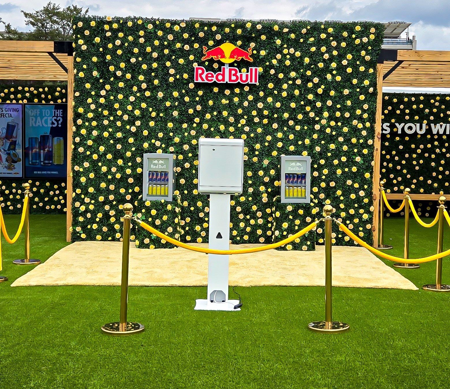 Pose 502 Portrait Booth set up in front of Red Bull's yellow rose flower wall in the Churchill Downs infield