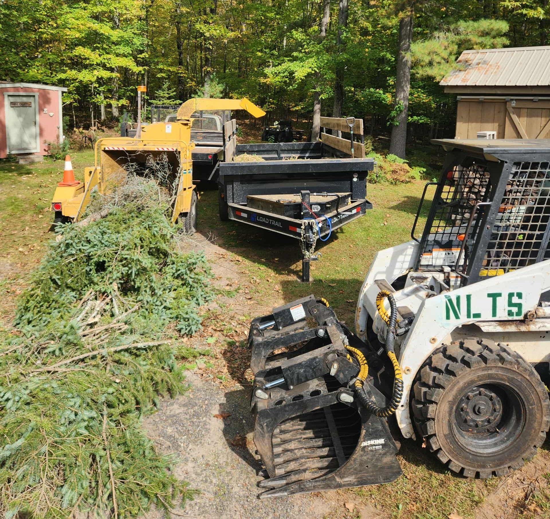 A chainsaw cuts into a log, scattering wood chips. A gloved hand holds the saw.