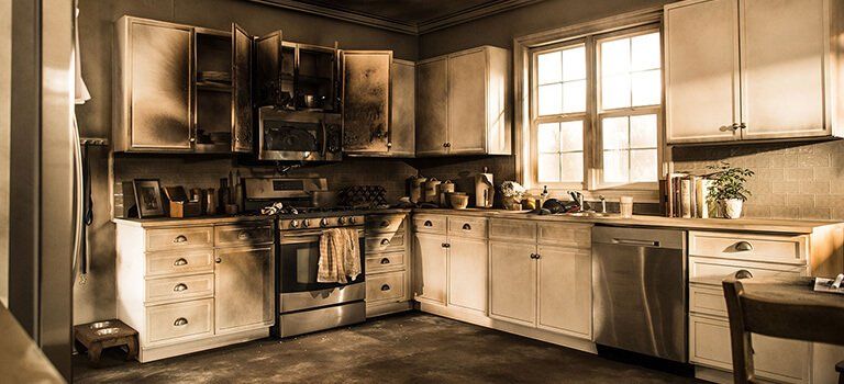 A kitchen with a stove , dishwasher , cabinets , and a window.