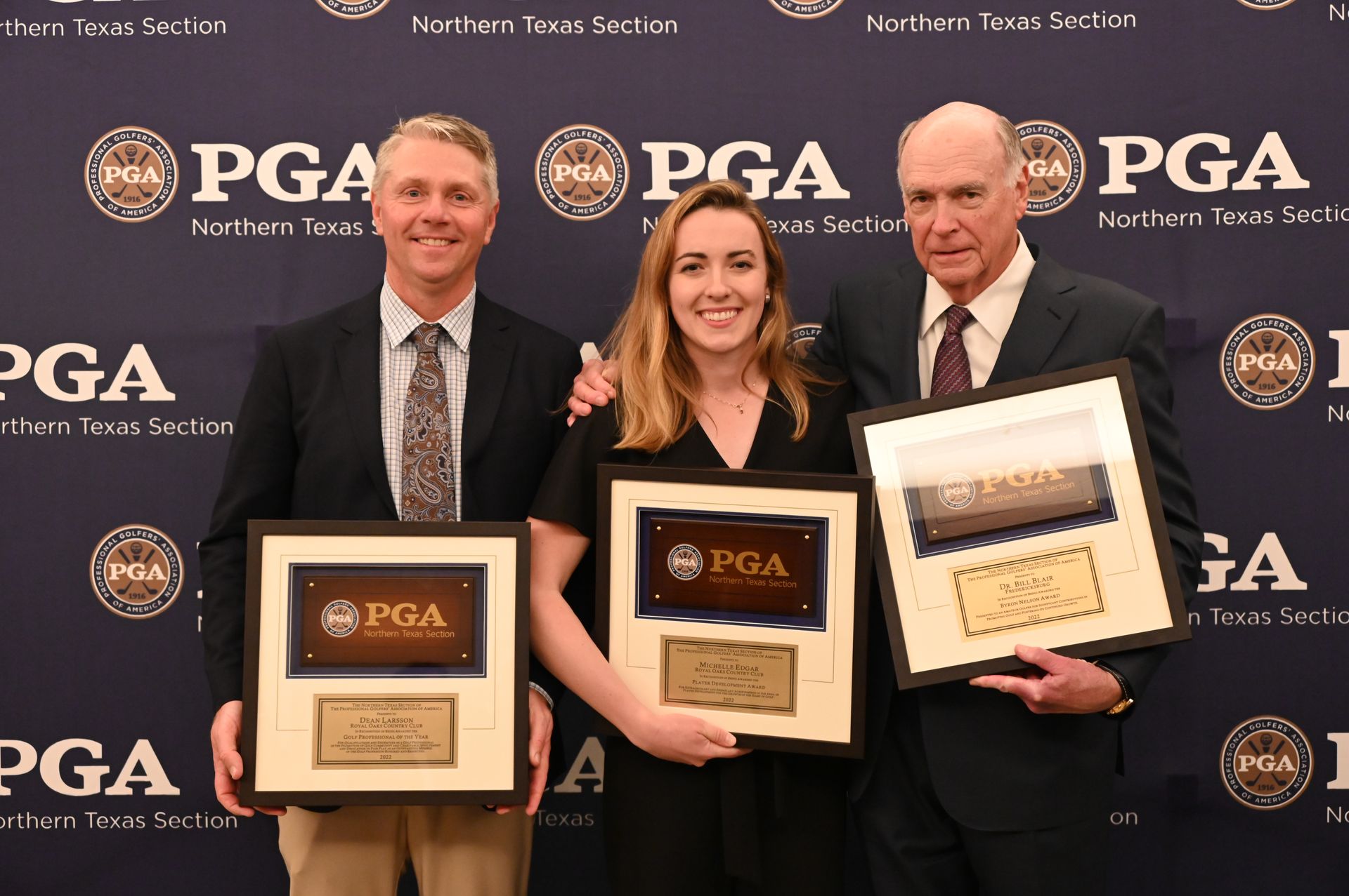 Three people holding award plaques at a PGA event in front of a PGA and DGA backdrop