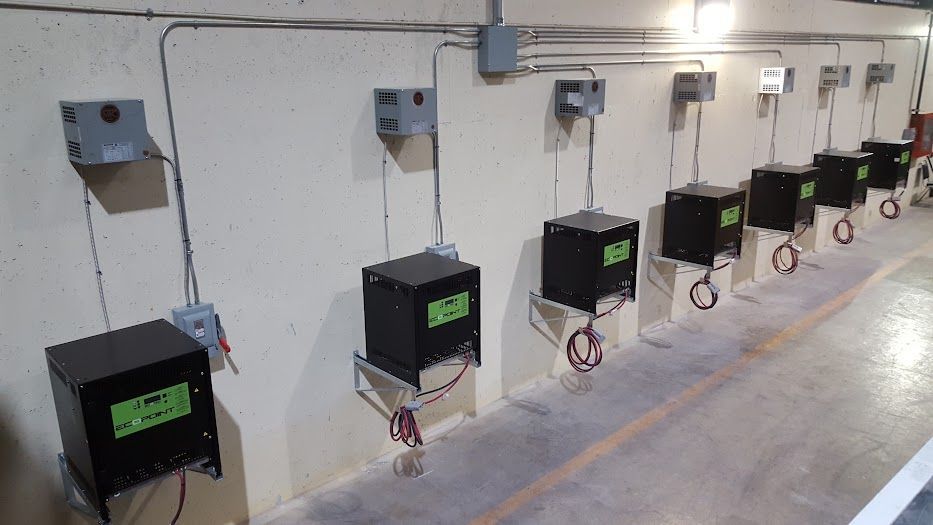 A row of black boxes hanging on a wall in a room.