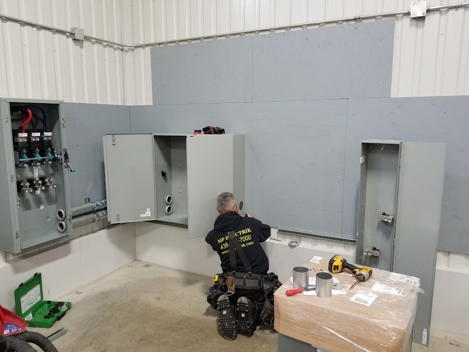 A man is working on a electrical box in a room.