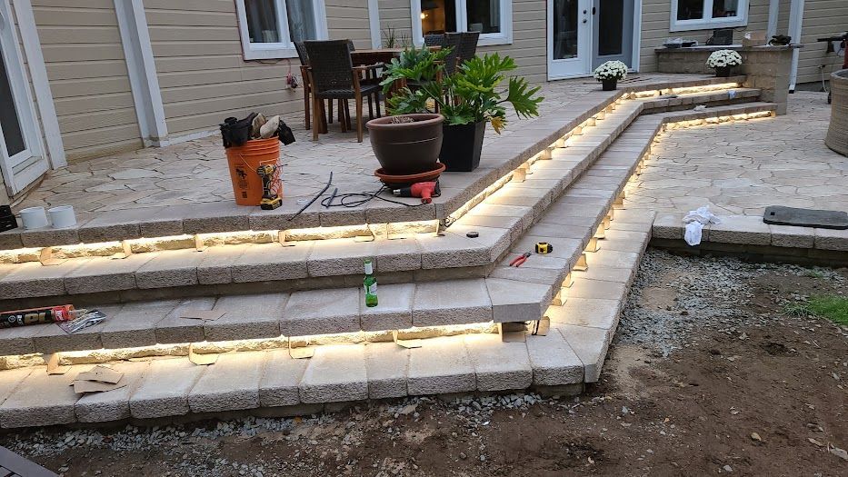 A patio with stairs and lights on it is being built.
