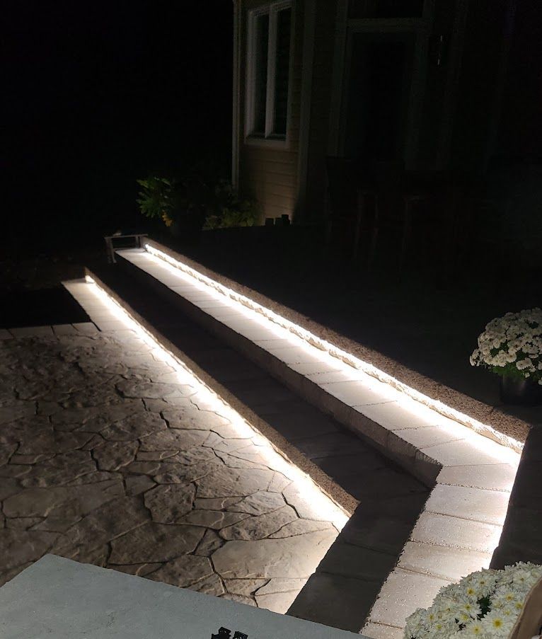 A walkway with lights on it is lit up at night.