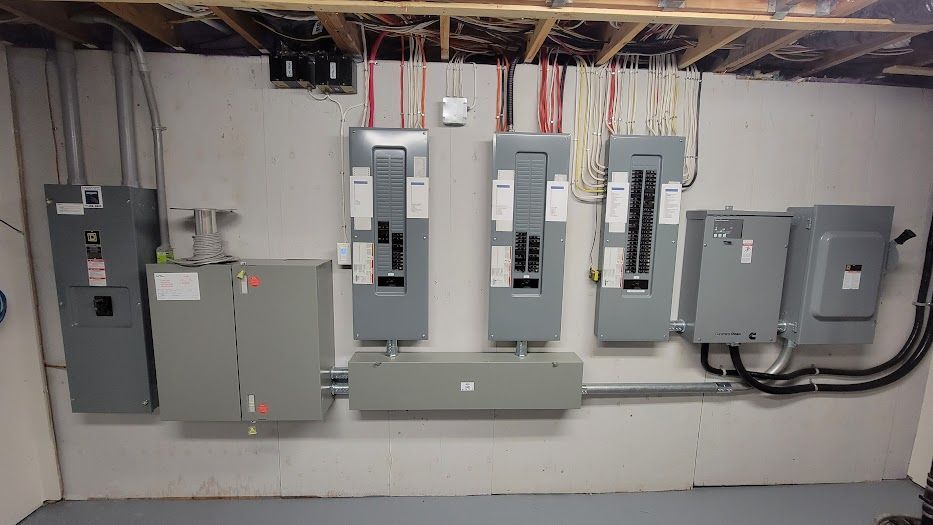 A bunch of electrical panels are hanging on a wall in a room.