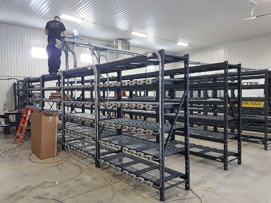 A man is standing on top of a metal rack in a warehouse.