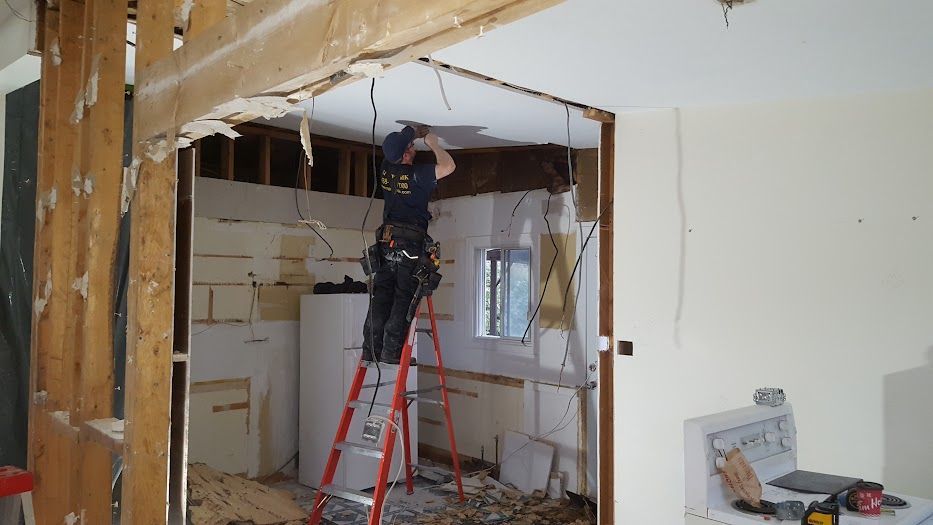 A man is standing on a ladder in a room.