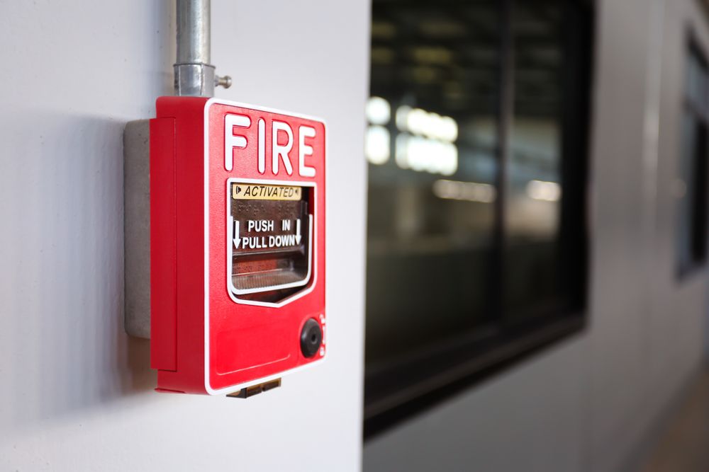A Row of Red Fire Extinguishers Are Lined up On a Wall — Test Right Services in Ingham, QLD