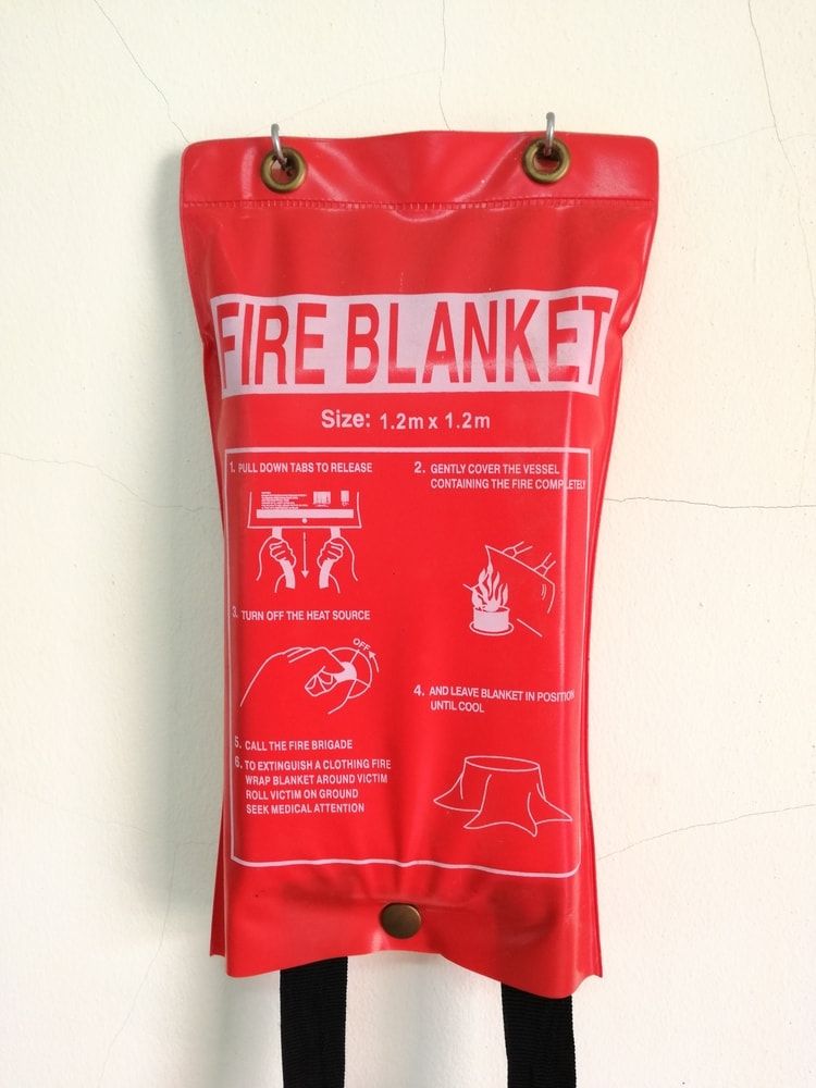 Red Fire Blanket in A Pouch Hanging on A Wall, with Instructions and Metal Grommets — Test Right Services in Ayr, QLD
