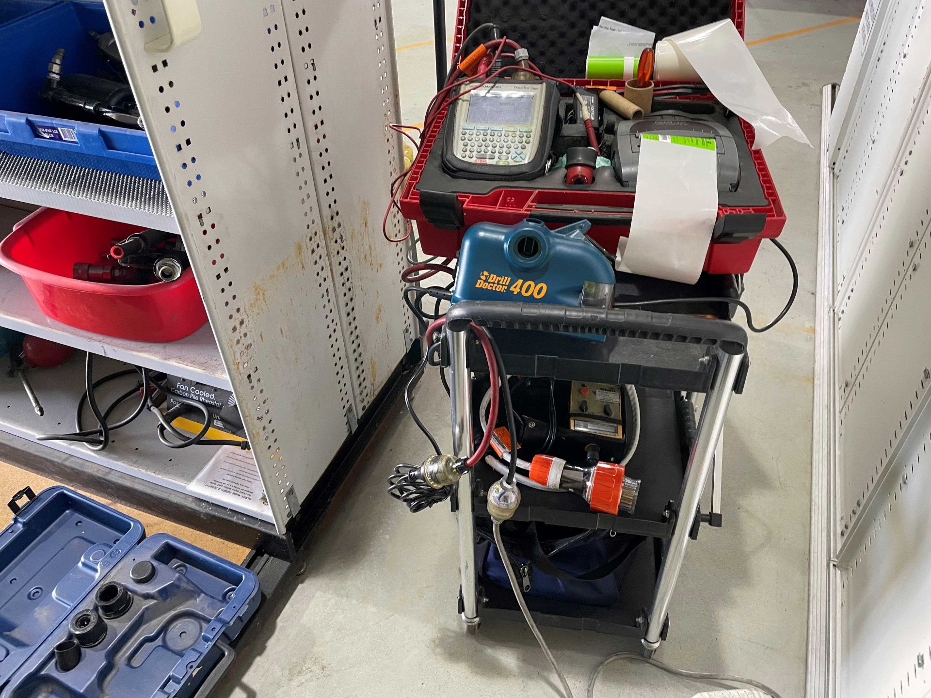Diagnostic equipment on a wheeled cart in a workshop, with shelves of tools and equipment nearby.— Test Right Services in Ingham, QLD